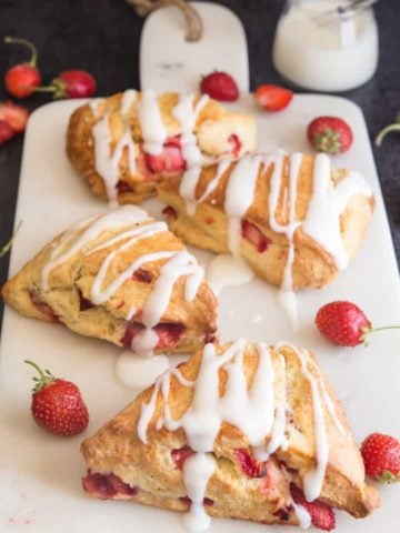 5 strawberry scones with glaze on a white board