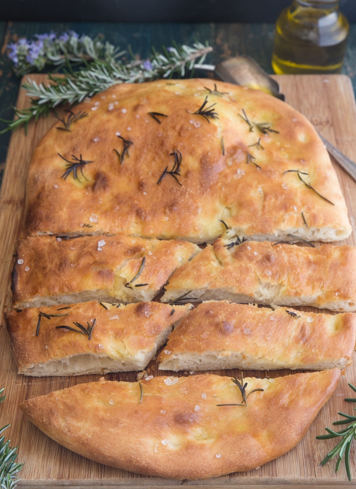 focaccia on a wooden board, with half pieces sliced