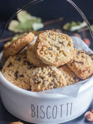 Oatmeal cookies in a white biscotti bowl.